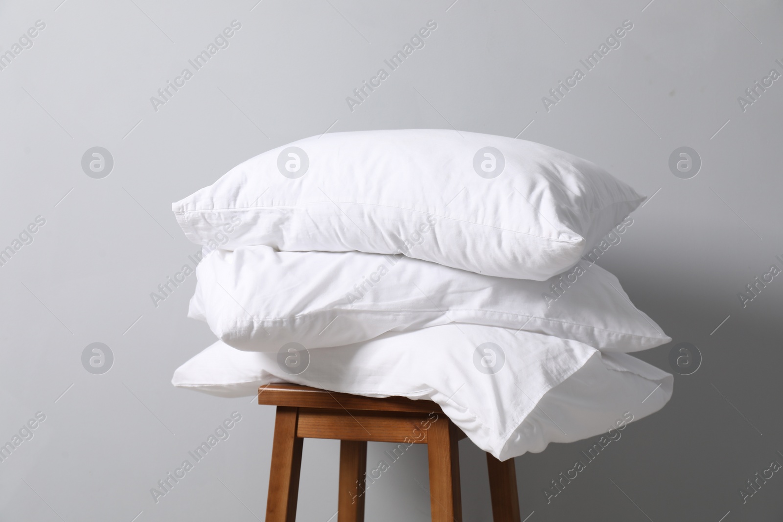 Photo of Soft pillows on chair neal light grey wall