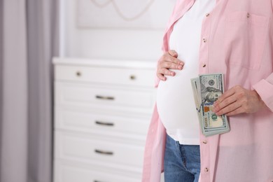 Photo of Surrogate mother. Pregnant woman with dollar banknotes indoors, closeup. Space for text