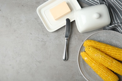 Photo of Flat lay composition with boiled corn cobs on light grey table. Space for text
