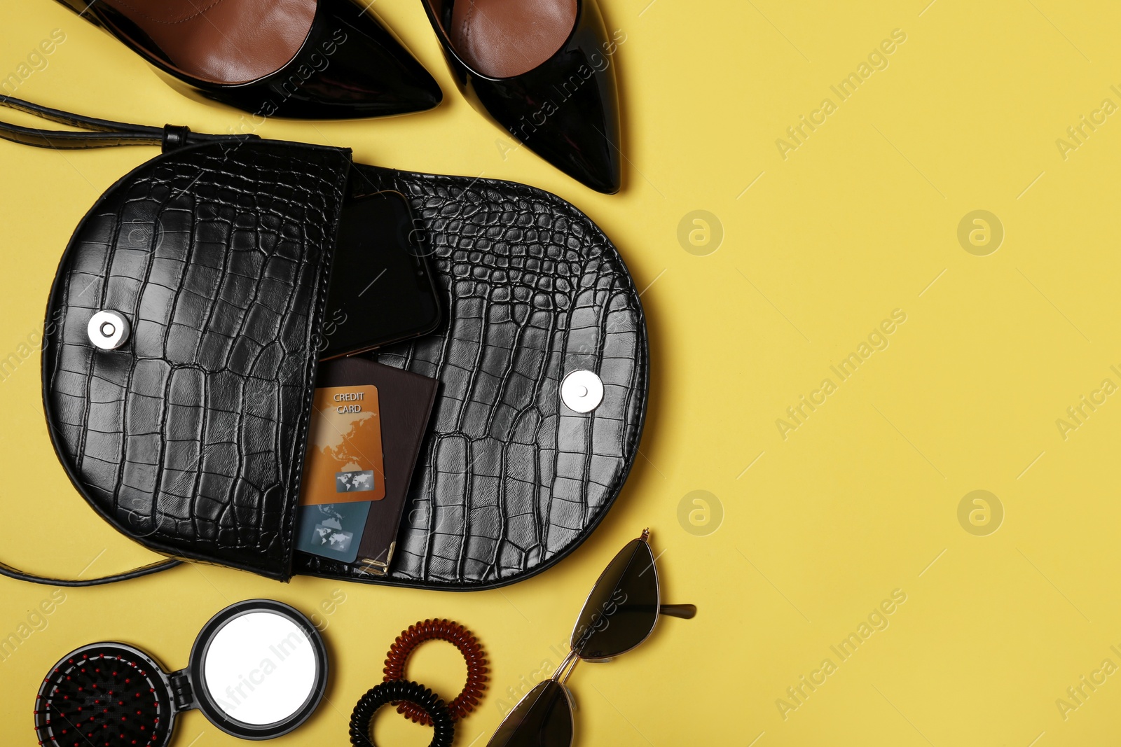 Photo of Flat lay composition with stylish woman's bag on light yellow background. Space for text