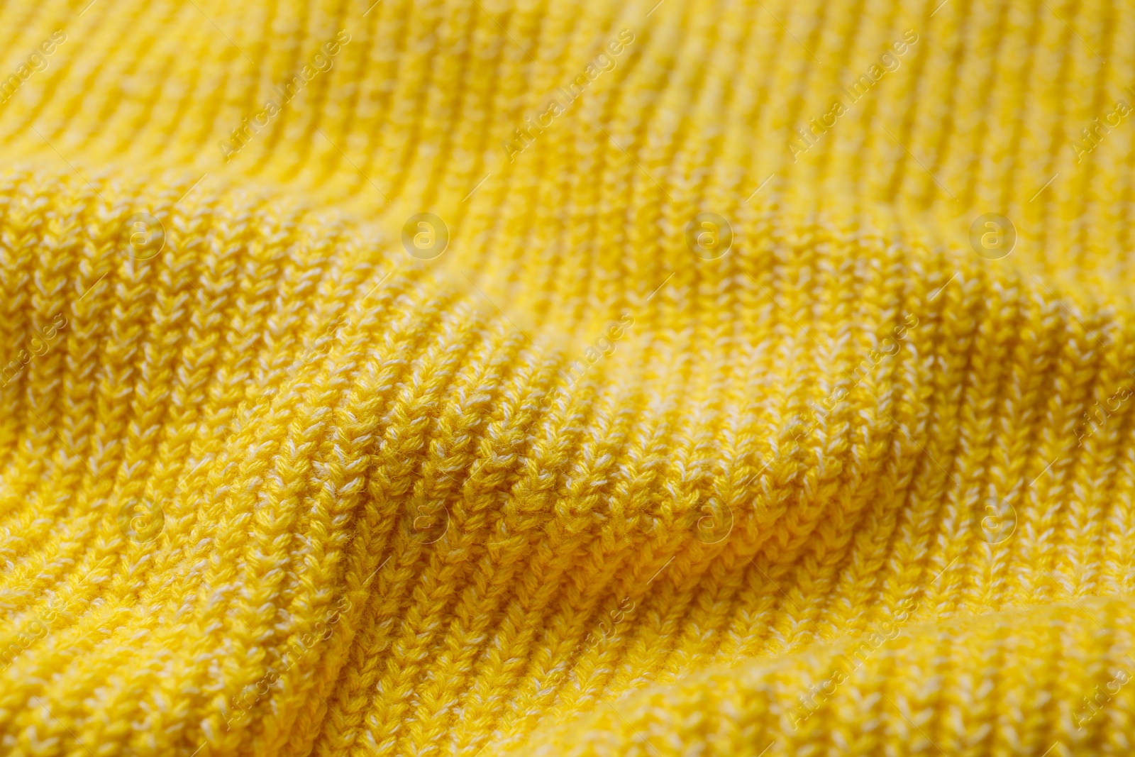 Photo of Yellow knitted fabric as background, closeup view