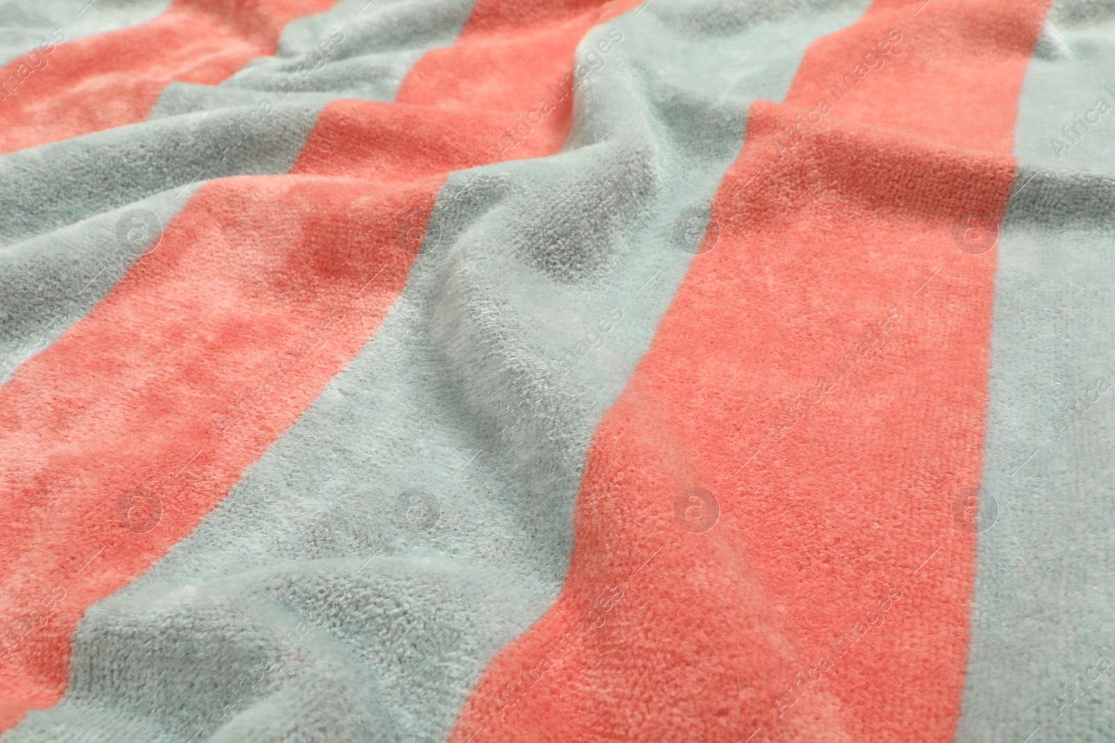 Photo of Crumpled striped beach towel as background, closeup view