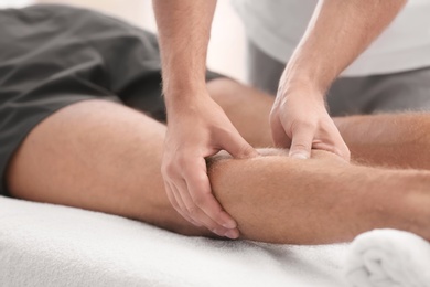 Photo of Young man receiving massage in salon, closeup