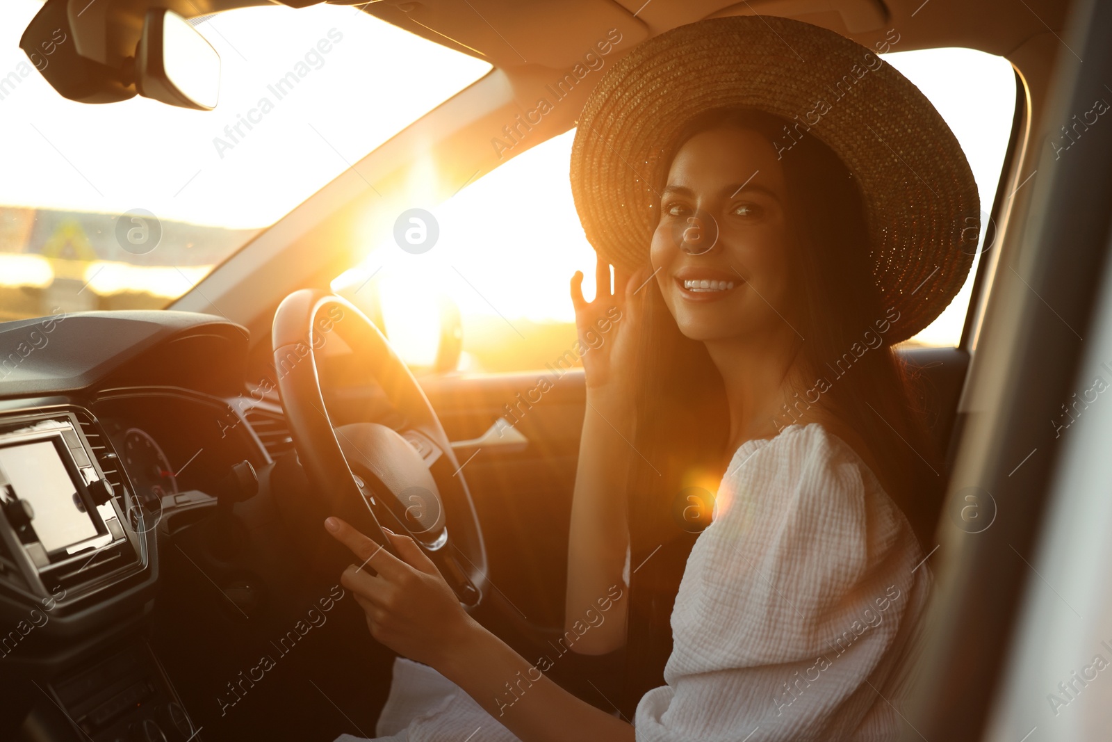 Photo of Beautiful young woman sitting in her car. Enjoying trip