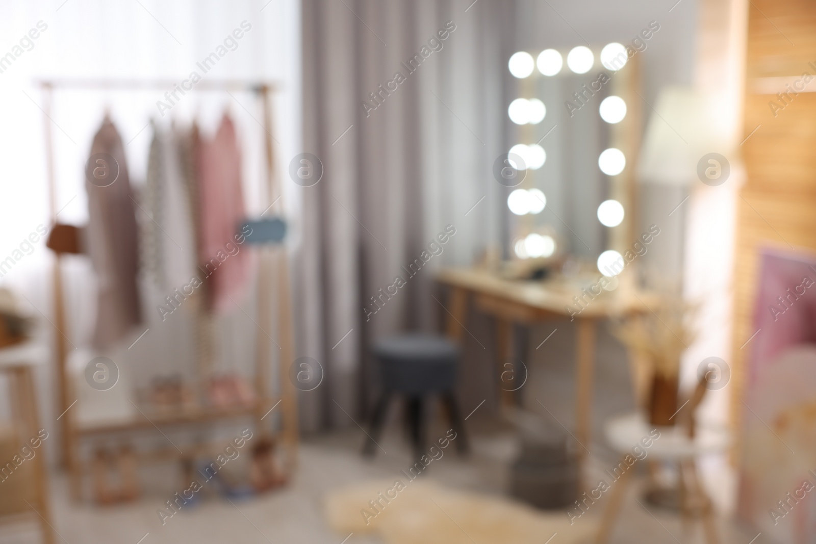 Photo of Blurred view of makeup room with stylish mirror, dressing table and chair