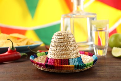 Mexican sombrero hat and tequila on wooden table