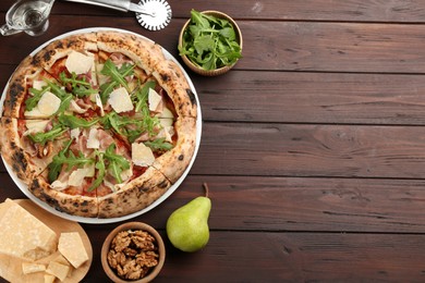 Tasty pizza with meat and arugula on wooden table, flat lay. Space for text