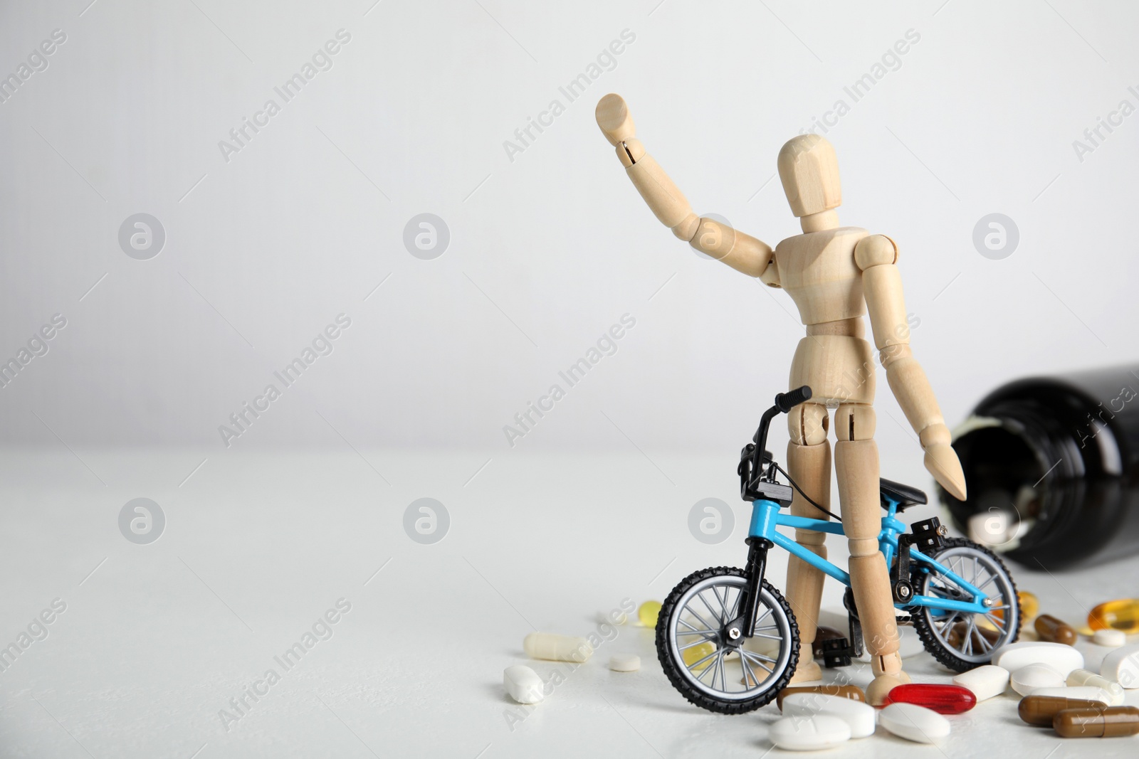 Photo of Pills, sportsman and bike model on white table, space for text. Using doping in cycling sport concept