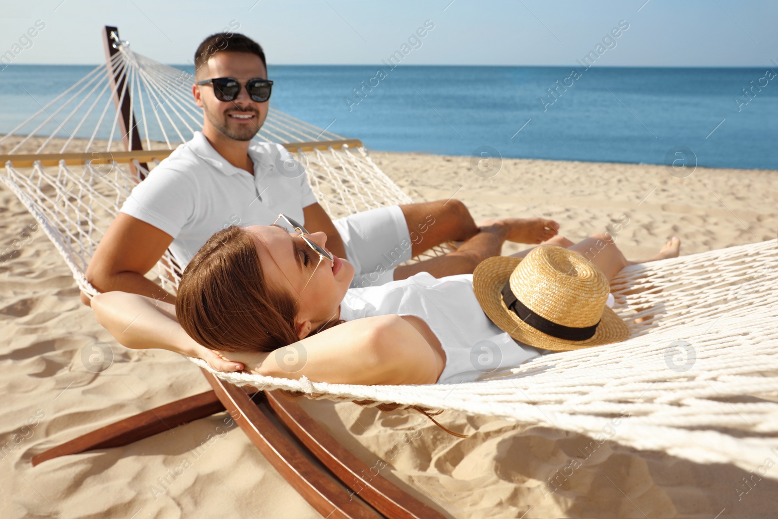 Photo of Young lovely relaxing in hammock on beach