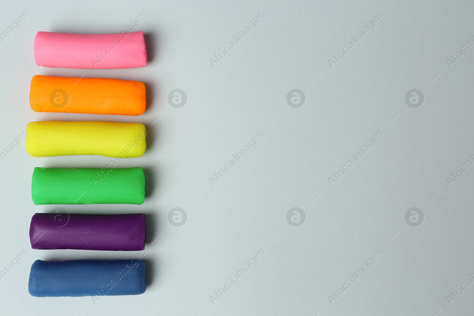 Photo of Different color play dough on light grey background, flat lay. Space for text