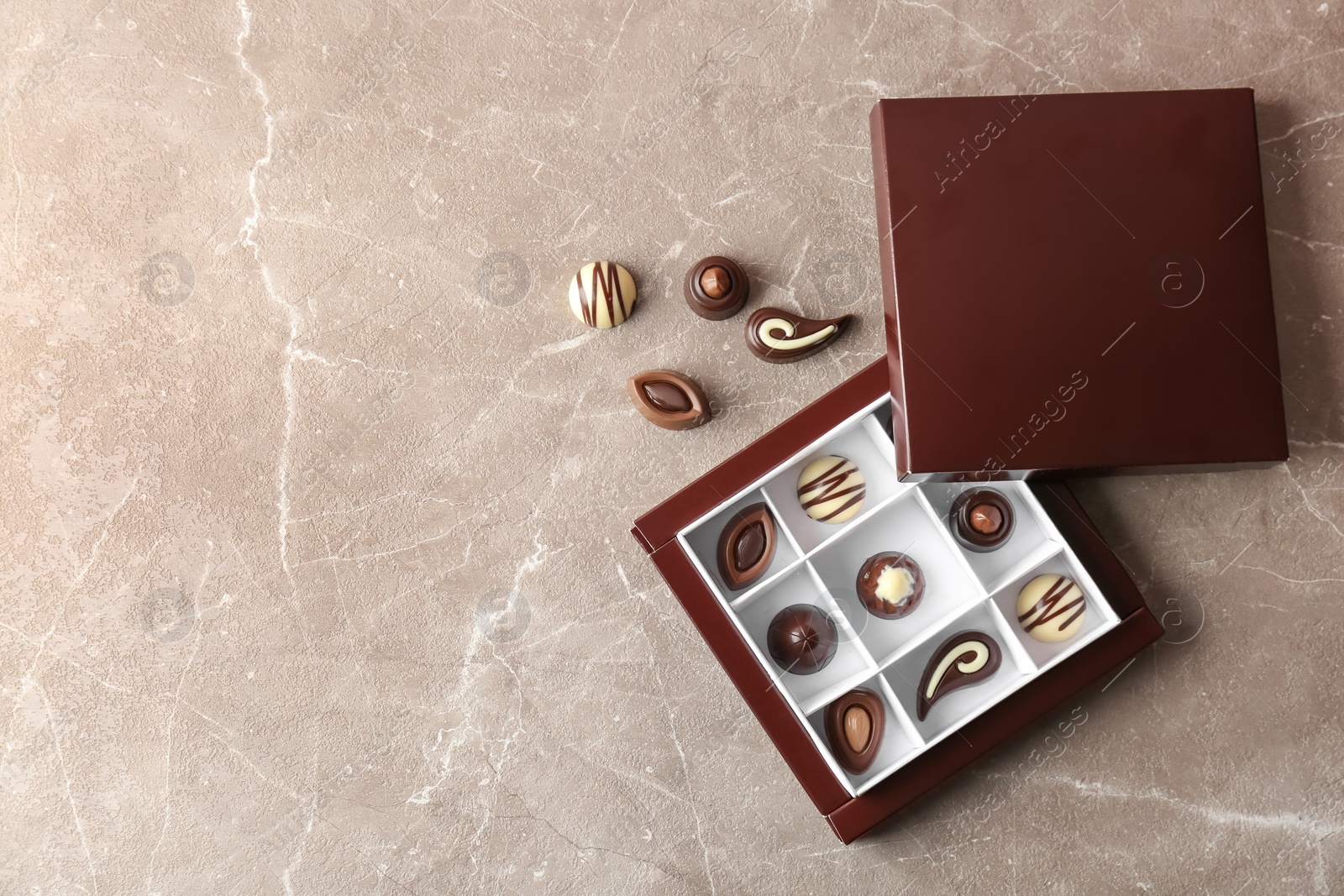 Photo of Box with different tasty chocolate candies on table, top view