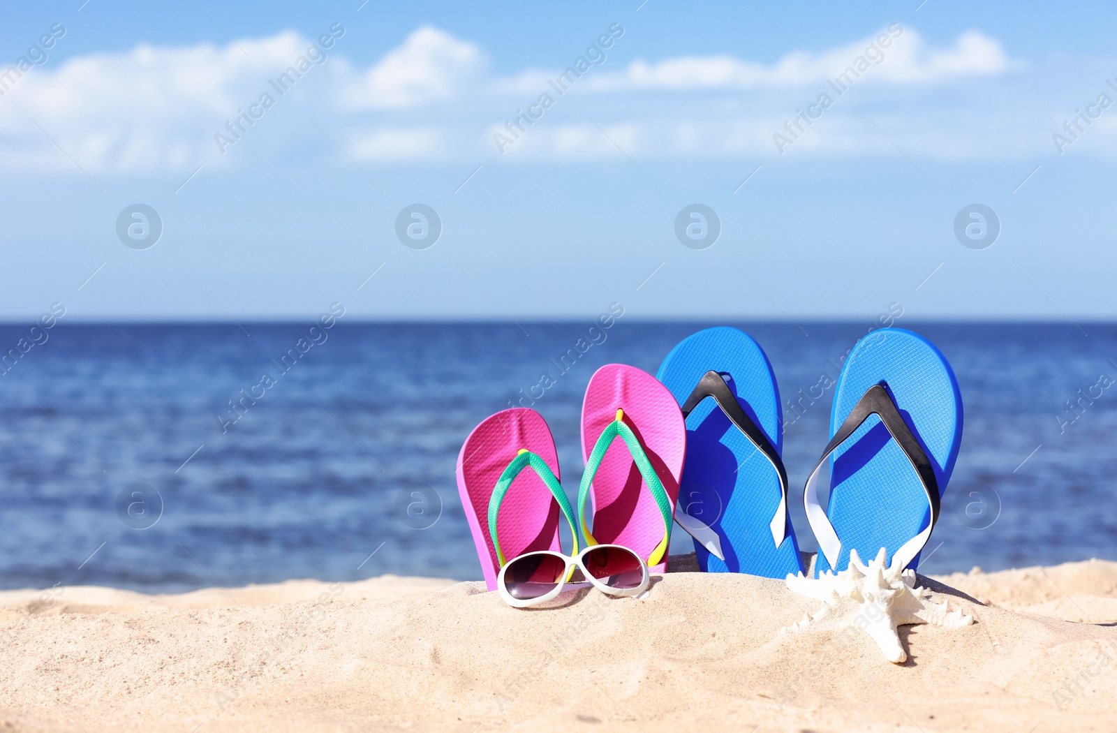 Photo of Composition with beach accessories on sand near sea in summer. Space for text