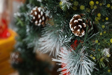 Photo of Fir tree branches with cones, closeup view. Christmas decor