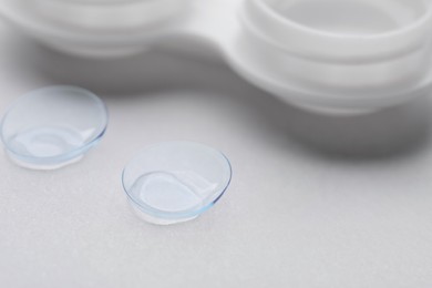 Photo of Contact lenses and case on white background, closeup
