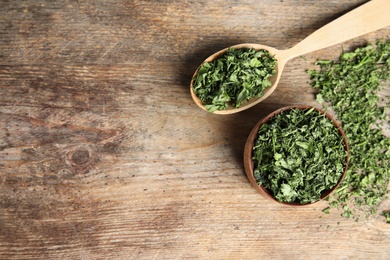 Flat lay composition with dried parsley on wooden table. Space for text