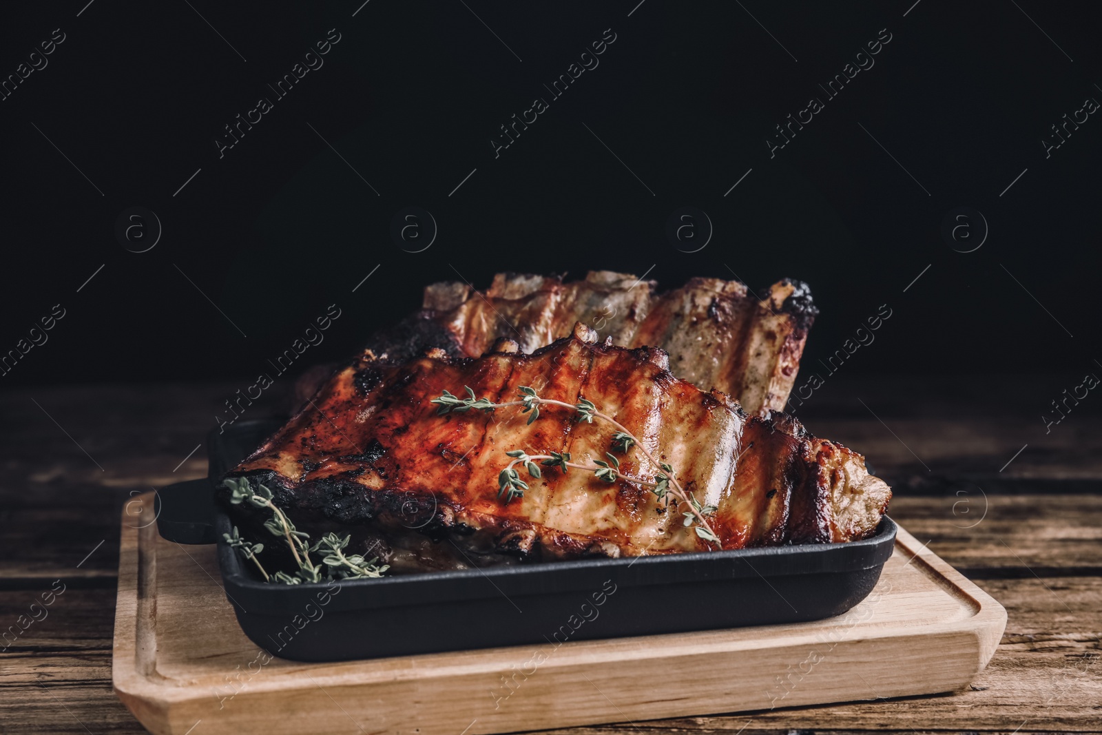 Image of Tasty grilled ribs with thyme on wooden table. Food photography  