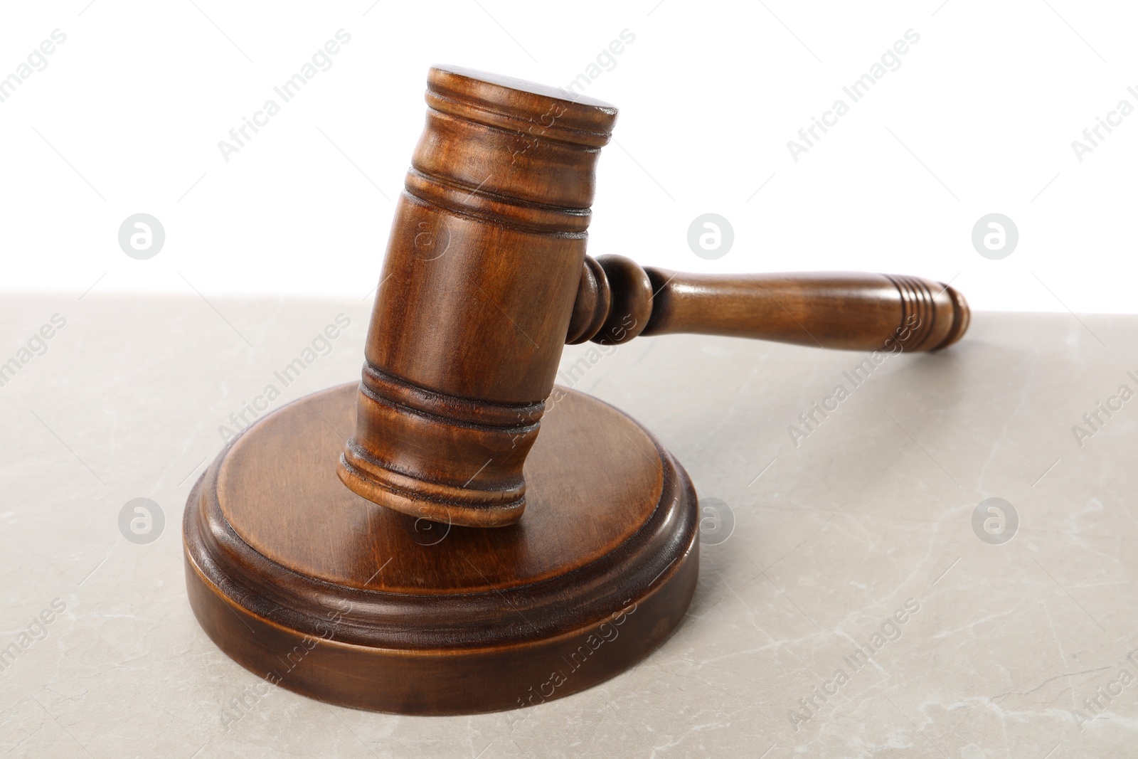 Photo of Wooden gavel on light table against white background