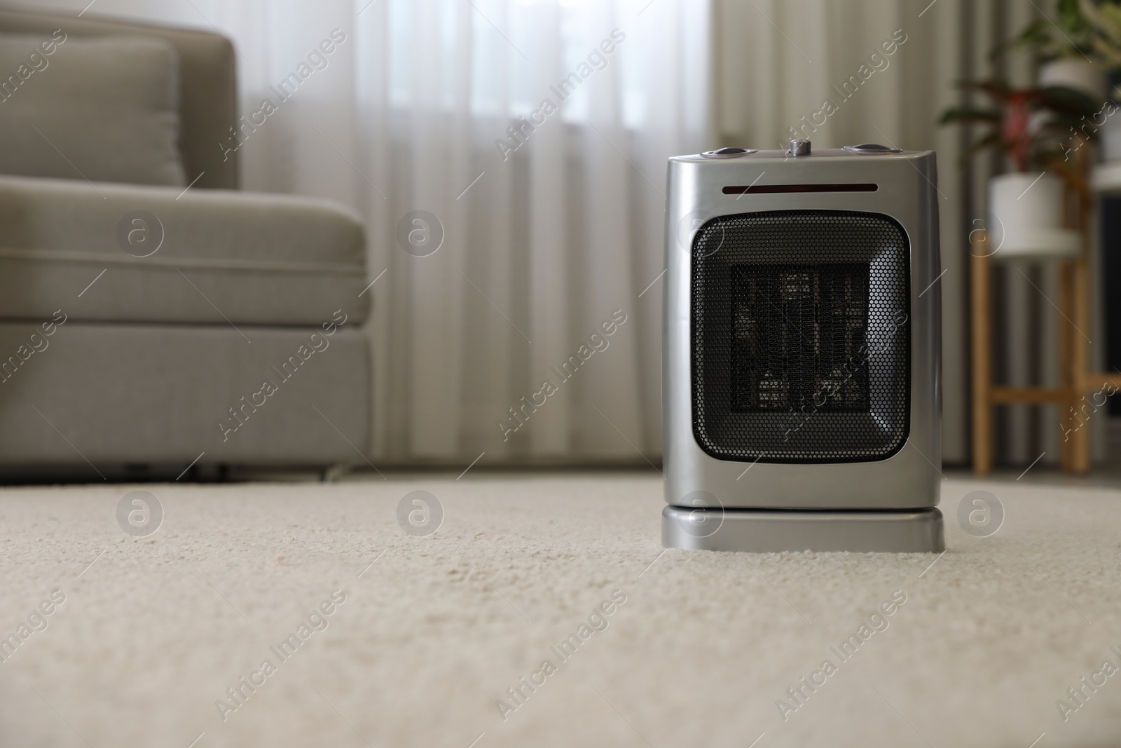 Photo of Modern electric infrared heater on floor in room interior. space for text