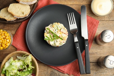 Photo of Delicious salad with crab sticks served on wooden table, flat lay