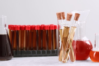 Different laboratory glassware with brown liquids on white table