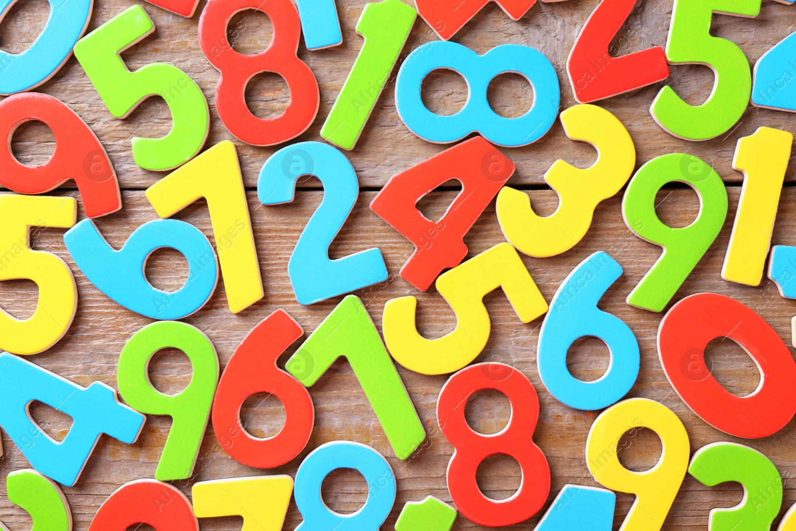 Photo of Colorful numbers on wooden table, flat lay