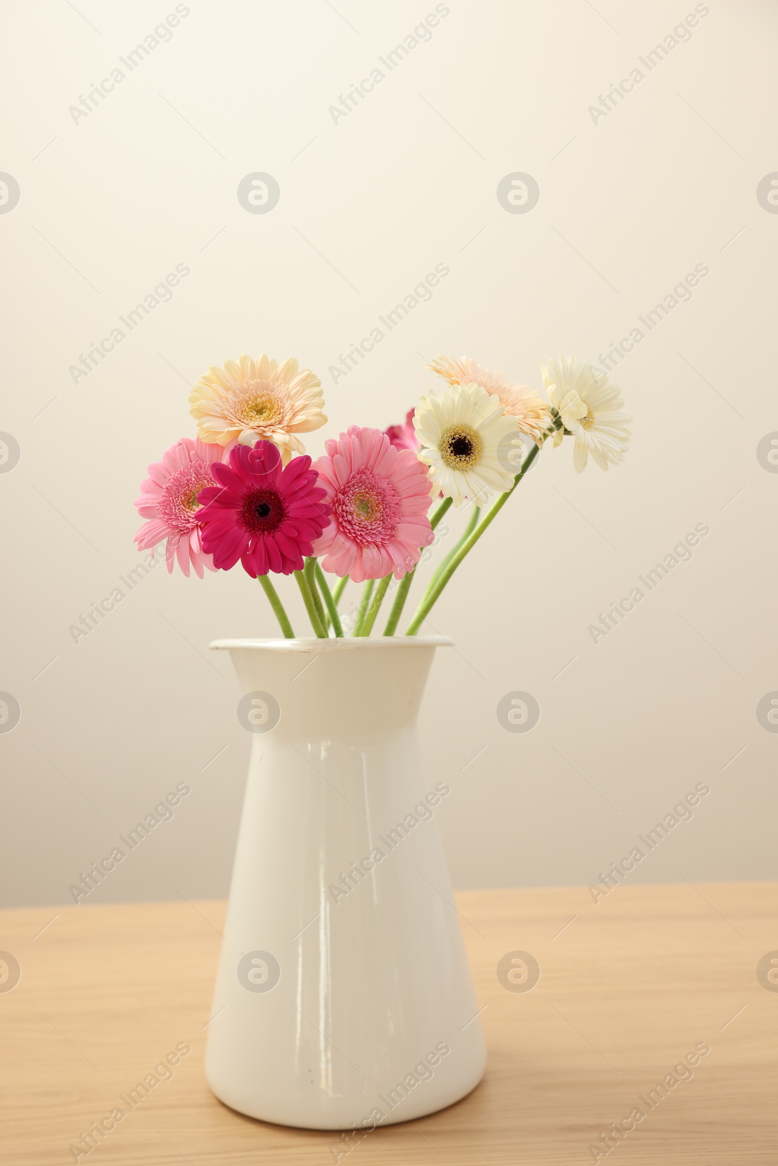 Photo of Vase with beautiful gerbera flowers on wooden table