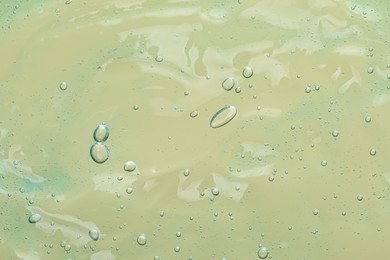 Photo of Transparent cleansing gel on olive background, top view. Cosmetic product
