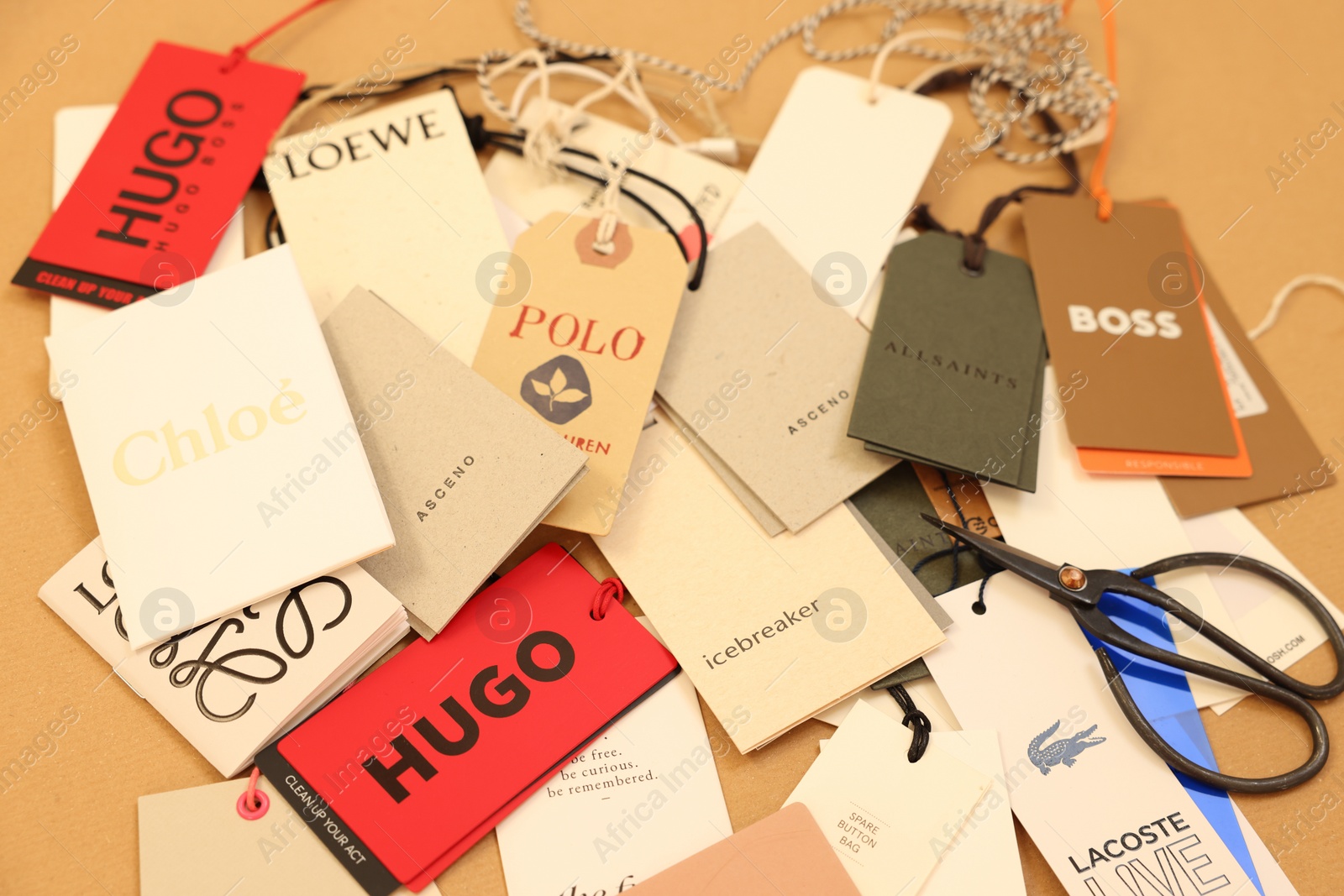 Photo of Leiden, Netherlands - December 6, 2023: Different clothing tags and scissors on kraft paper sheet