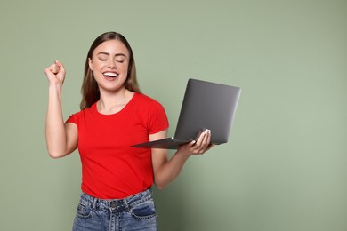 Photo of Happy woman with laptop on pale green background. Space for text