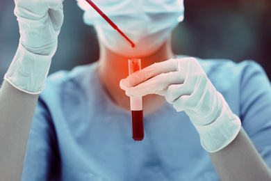 Image of Scientist dripping blood into test tube, closeup. Laboratory analysis