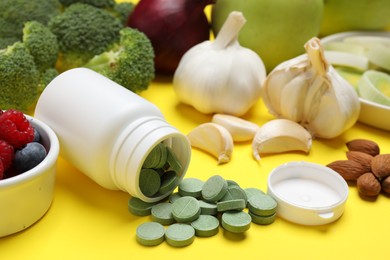 Food and bottle of prebiotic pills on yellow background, closeup