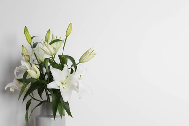 Beautiful bouquet of lily flowers in vase on white background, space for text