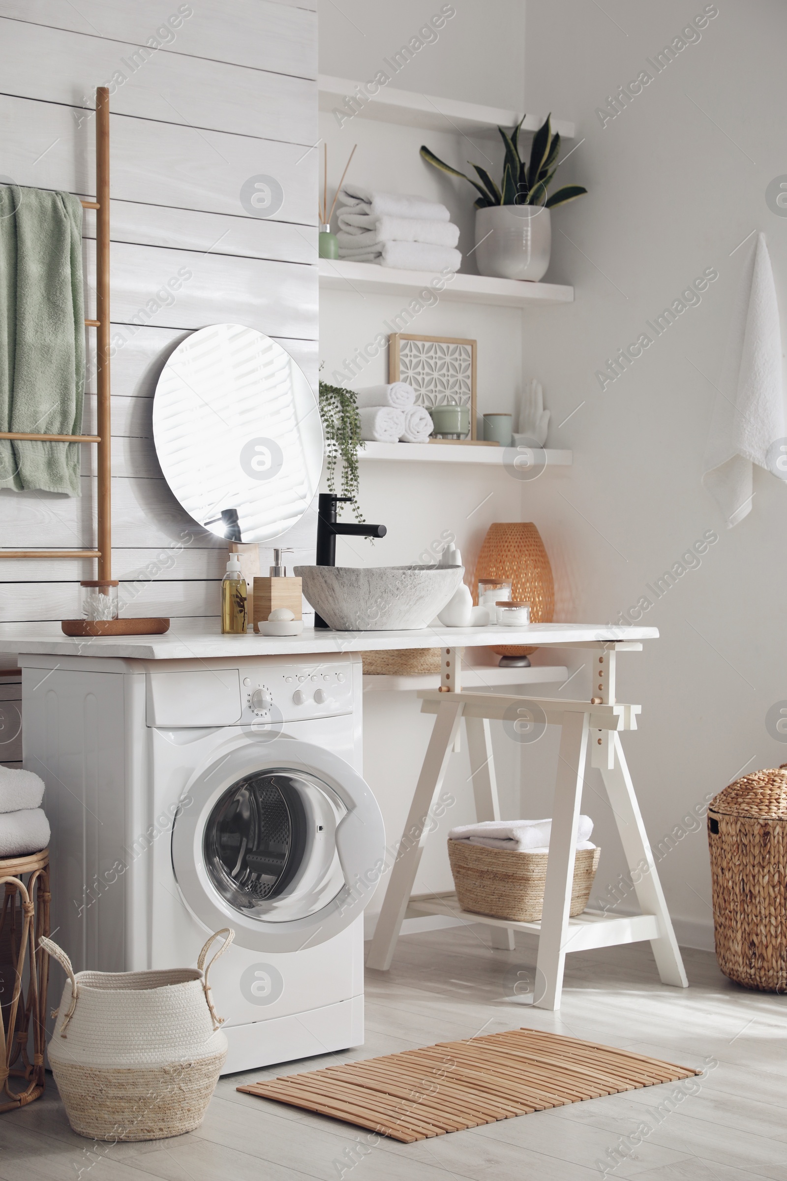 Photo of Stylish bathroom interior with modern washing machine