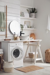 Photo of Stylish bathroom interior with modern washing machine