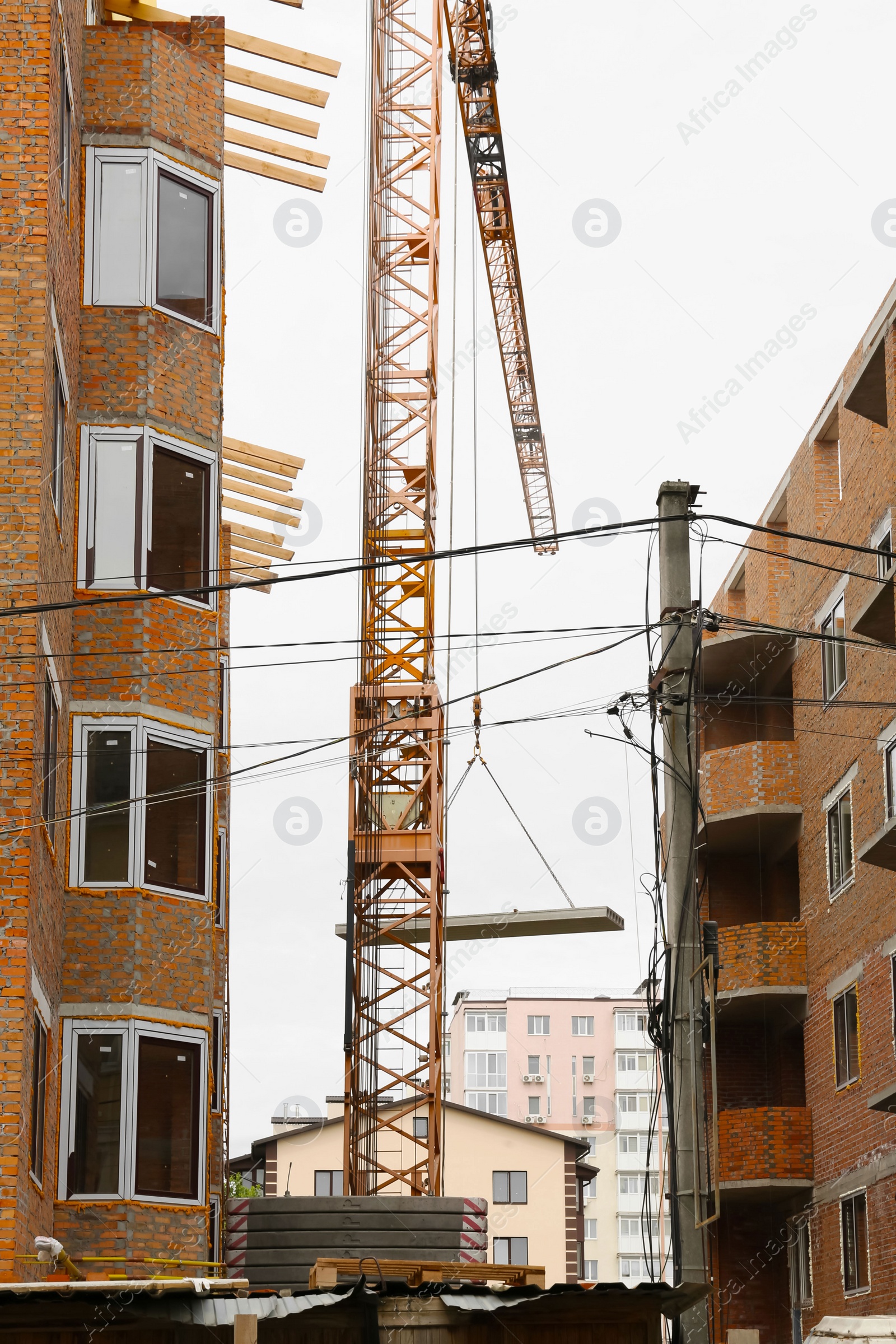 Photo of Construction site with tower crane near unfinished buildings