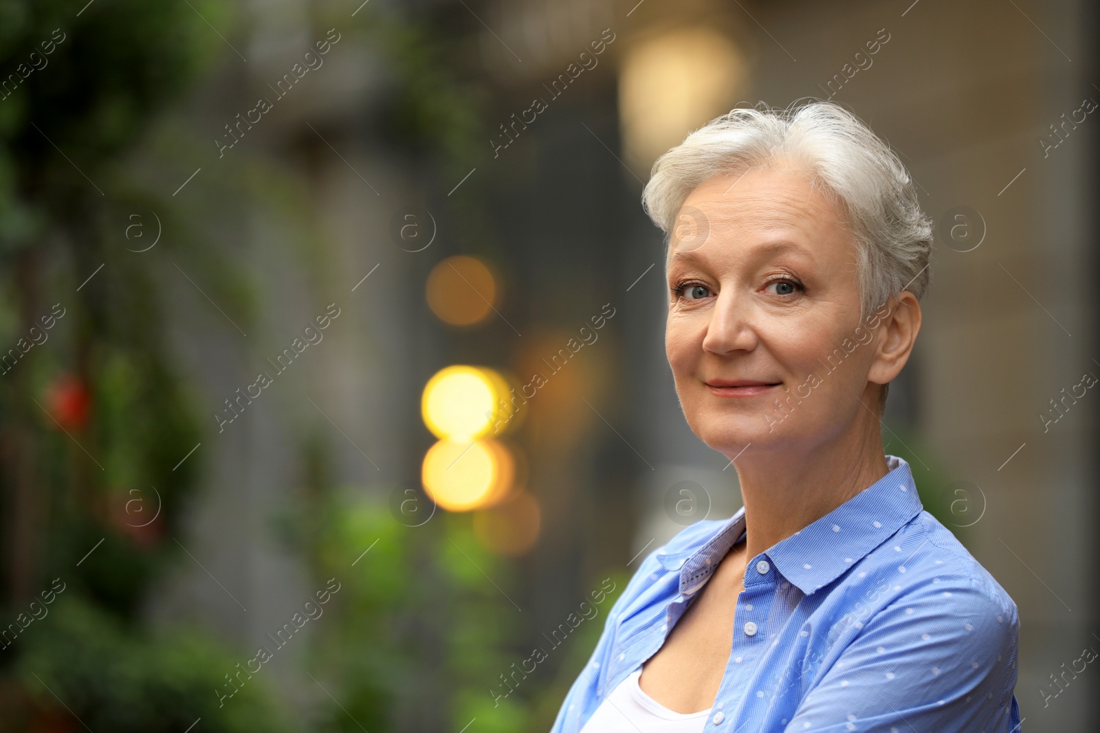 Photo of Happy mature woman on city street, space for text. Smart aging