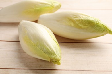 Photo of Raw ripe chicories on wooden table, closeup