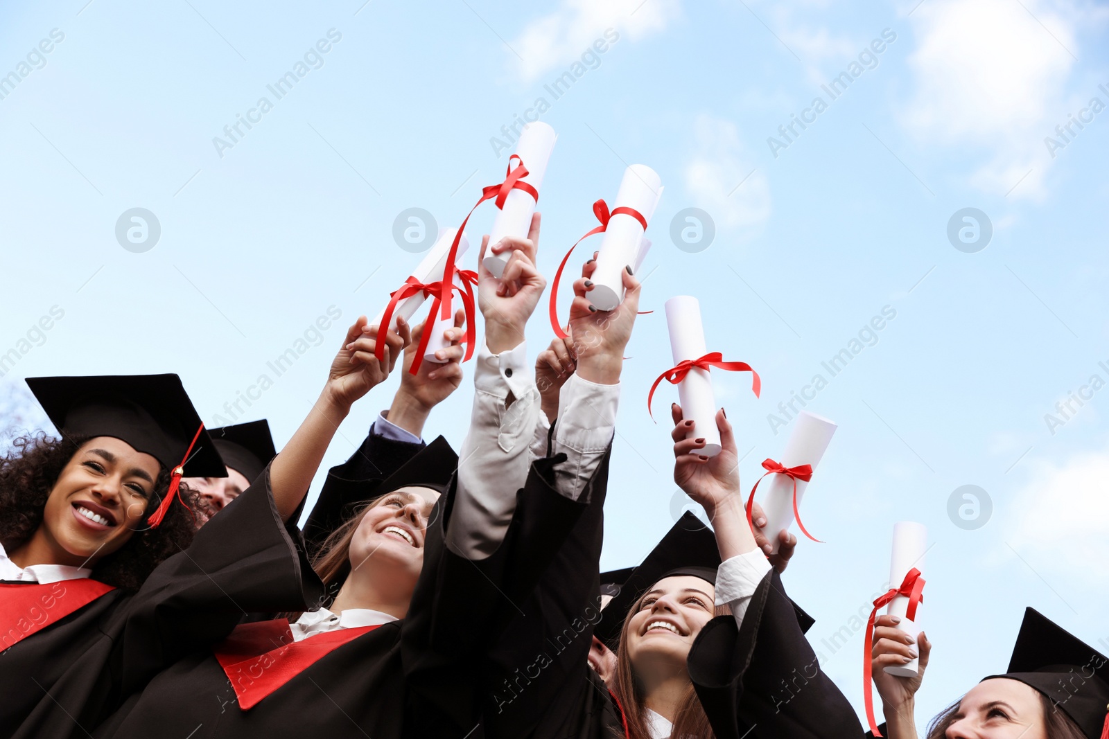 Photo of Happy students with diplomas outdoors. Graduation ceremony