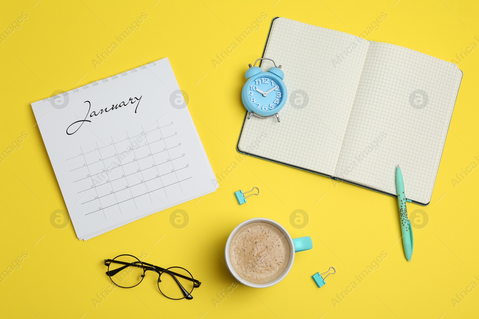 Photo of Flat lay composition with calendar and cup of coffee on yellow background