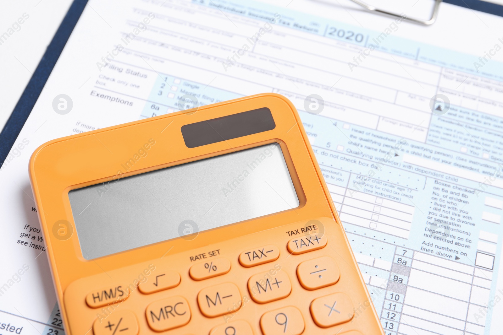 Photo of Calculator and document on table, closeup view. Tax accounting