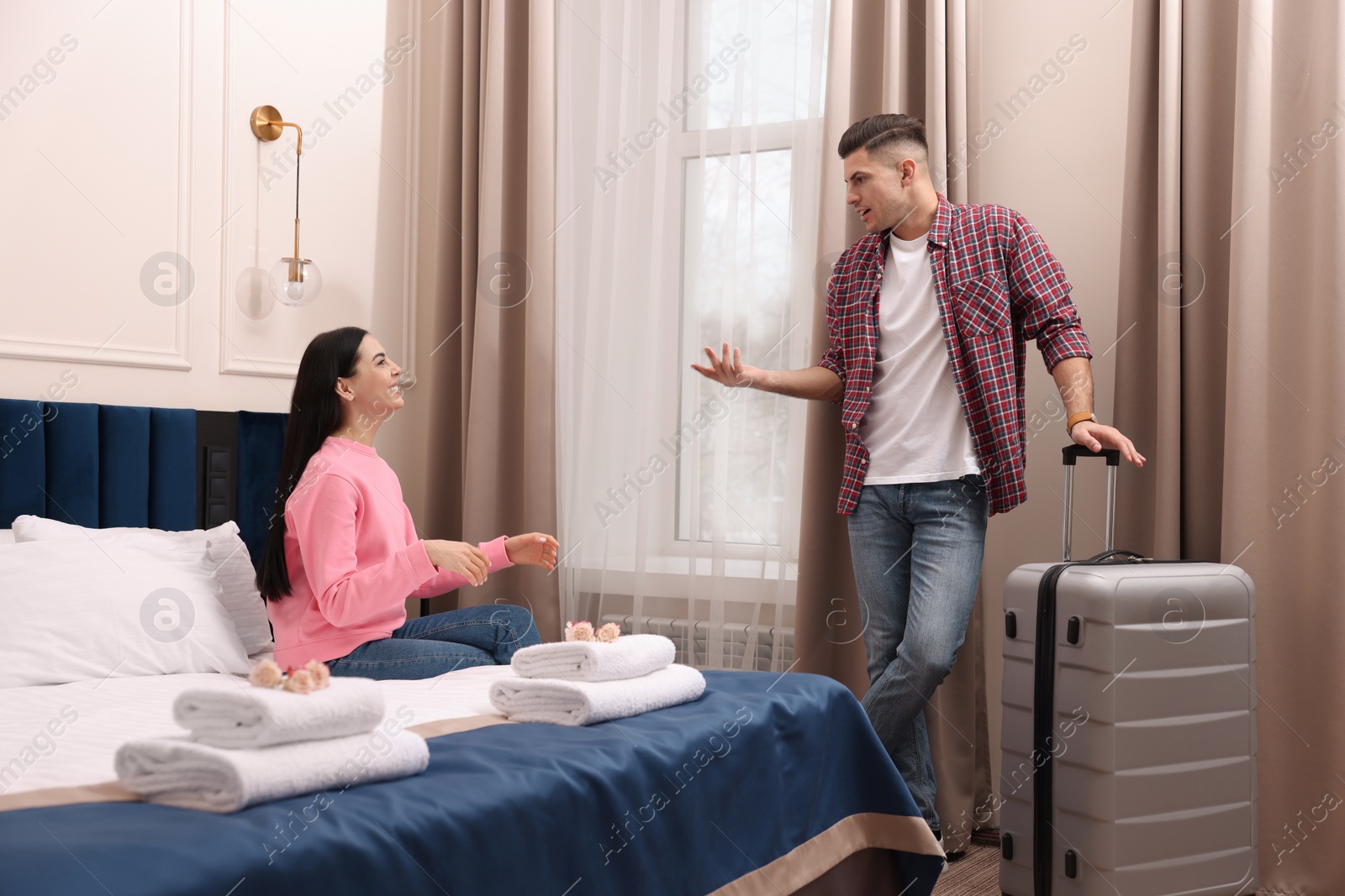 Photo of Happy couple having conversation in hotel room