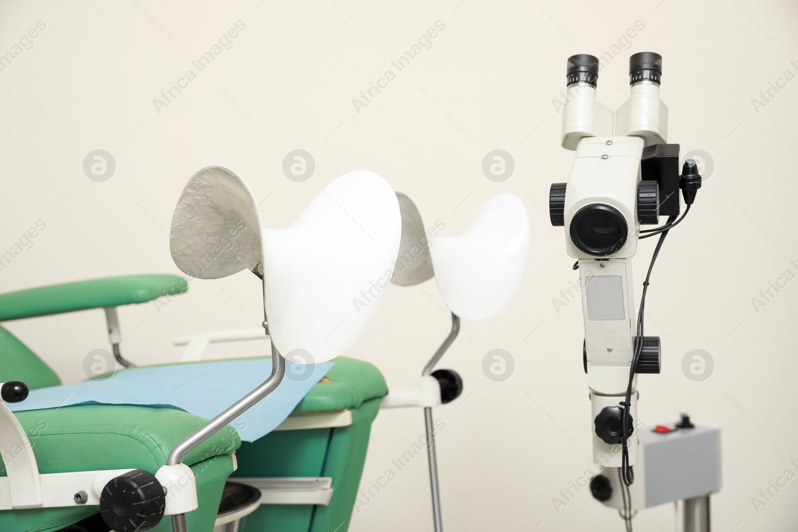 Photo of Modern binocular colposcope and gynecological chair in clinic