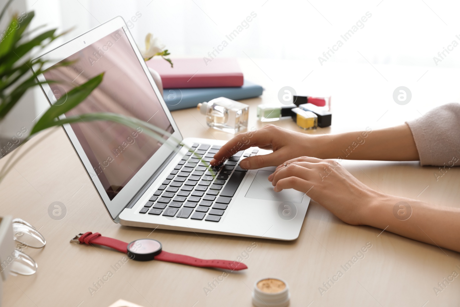 Photo of Blogger working with laptop at table, closeup