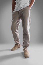 Photo of Man wearing stylish sneakers on light grey background, closeup