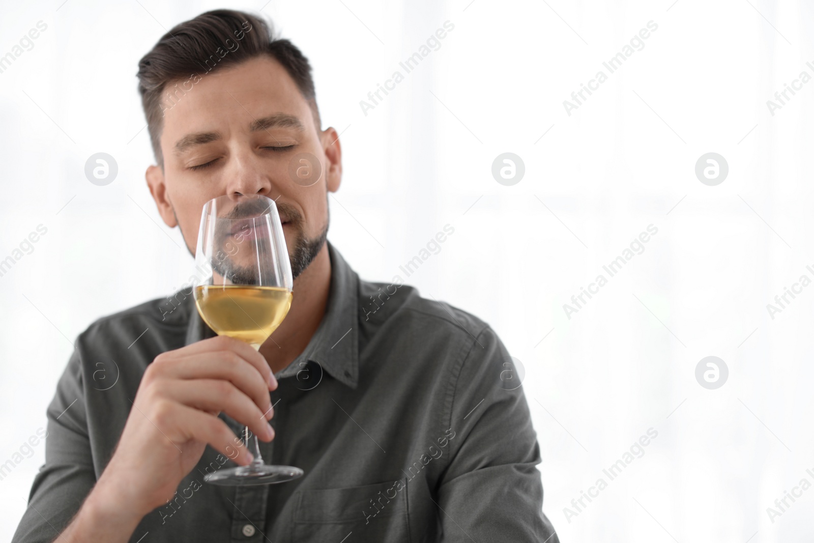 Photo of Man with glass of delicious wine indoors