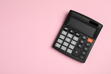 Calculator on pink background, top view. Space for text