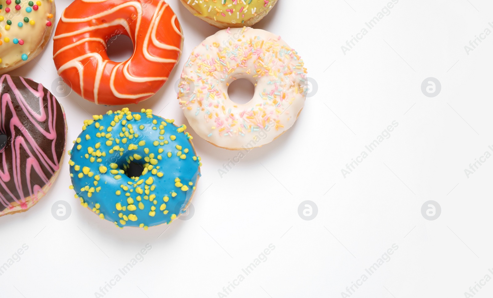 Photo of Delicious glazed donuts on white background, flat lay. Space for text