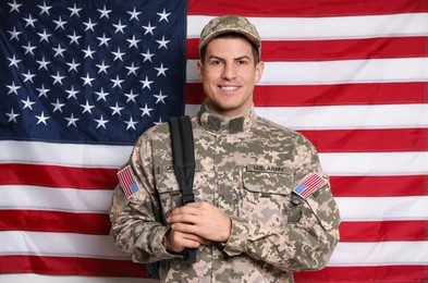 Photo of Cadet with backpack against American flag. Military education