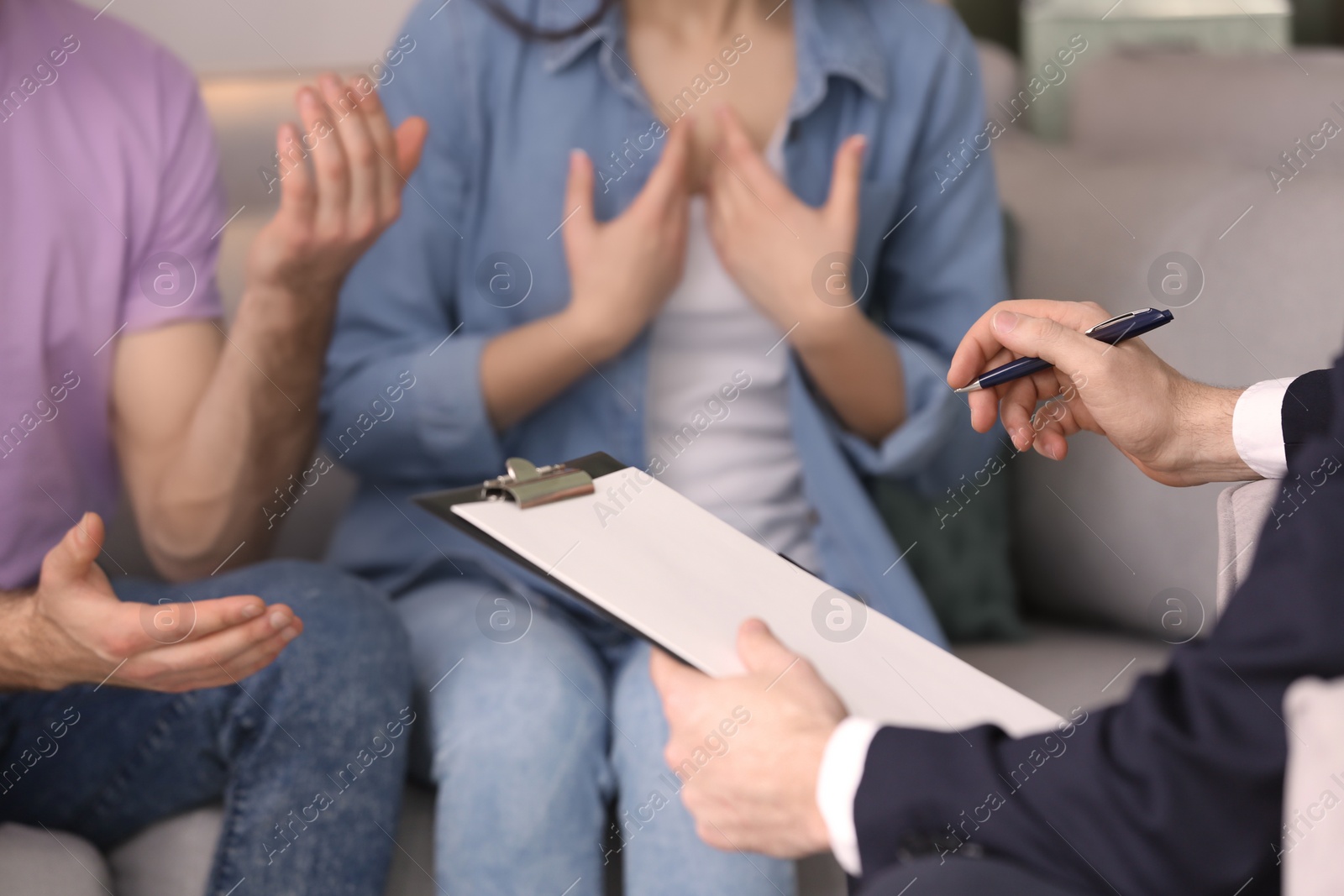 Photo of Family psychologist working with young couple in office, closeup