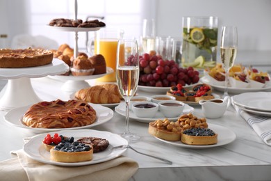 Variety of snacks on white marble table in buffet style indoors